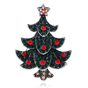 Macro shot of tiered Christmas tree brooch with deep green and red sparkling rhinestones