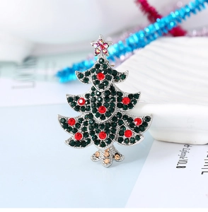 Close-up of a vintage silver Christmas tree brooch with green and red rhinestones