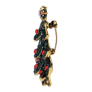 Detail view of the side profile and pin clasp on a vintage Christmas tree brooch with rhinestones