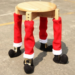 Close-up of Christmas chair leg covers in red fabric with black boot and gold buckle detail