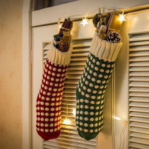 Chaussettes de Noël tricotées à pois avec cadeaux et guirlande lumineuse étoilée