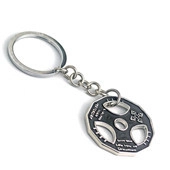 Detail view of silver barbell plate keychain with black paint and fitness engraving