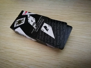 Close-up of mini playing cards in black and white box on a wooden surface