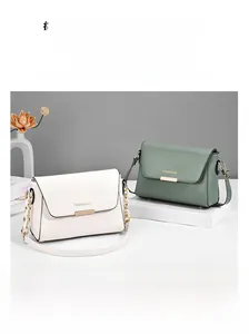 Detail of cream and sage green minimalist crossbody bags with gold metal clasps