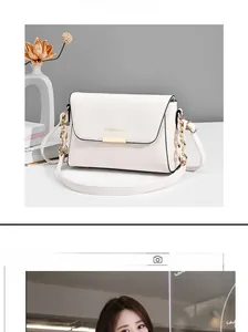 Detail of white leather crossbody bag with gold chain and Fashion & Bag lettering