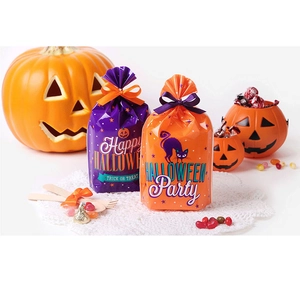 Close-up of Halloween treat bags with pumpkin prints and ribbon bows for party favors