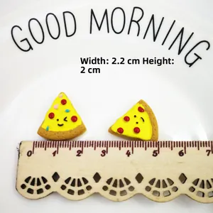 Close-up of resin mini pizza charms with cute cartoon faces and dimensions 2.2x2cm