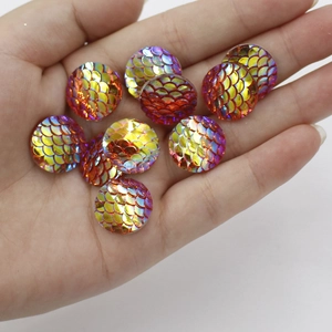 Macro shot of 16mm DIY resin cabochons with red and gold fish scale pattern