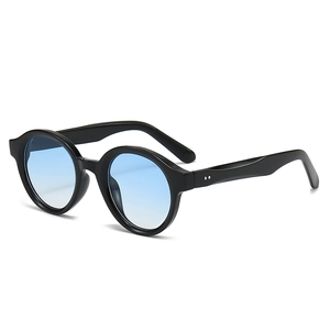 Oval chunky black sunglasses with blue gradient lenses and decorative silver rivets