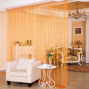 Tenda a frange arancione vivace utilizzata come divisorio decorativo in un soggiorno di lusso