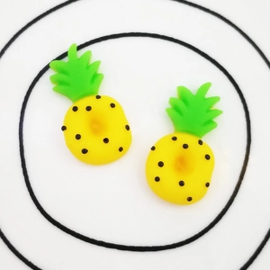 DIY resin pineapple charms for phone case decor and stationery on a white dish
