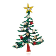 Close-up of a festive Christmas tree brooch with green enamel and colorful rhinestones