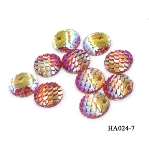 Macro detail of 16mm round resin cabochons with iridescent colorful fish scale patterns