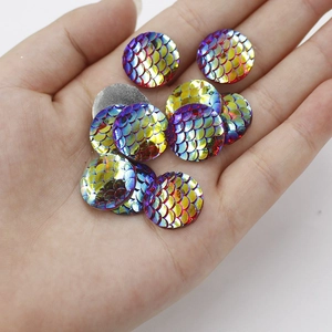 Detail showing 16mm round colorful mermaid fish scale resin cabochons held in hand