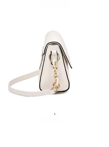 Detail shot of white crossbody bag with black contrast edges and gold chain strap accent