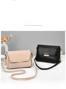 Detail view of stylish square flap handbags in beige and black with golden metal buckles