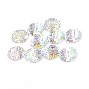 Macro shot of 16mm white iridescent resin round cabochons with fish scale texture detail