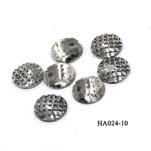 Macro detail of 16mm round resin cabochons with iridescent fish scale texture and dark silver finish