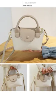 Detail van de beige en bruine handtas met litchi-patroon en gouden metalen delen