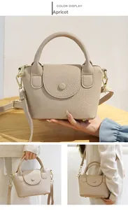Detail van de abrikooskleurige mini crossbodytas van hoogwaardig leer met lycheekorrel