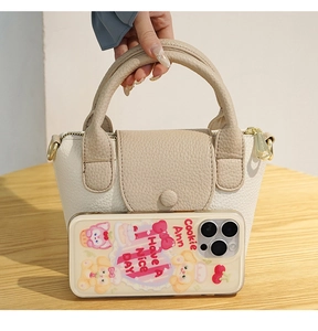 Detailweergave van crème bucketbag met getextureerd leer en gouden metalen ringen