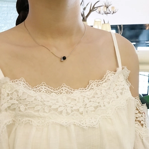 Minimalist 925 sterling silver necklace with black onyx beads worn by a model in white lace