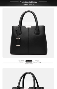 Detail view of black lychee grain leather handbag with gold hardware and logo tag