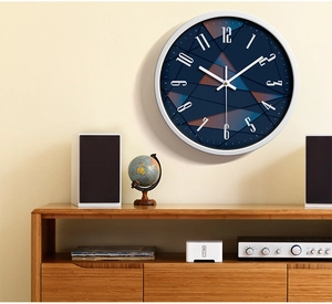 Close-up of modern navy blue wall clock dial with white pointers on beige wall