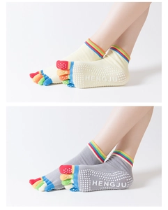 Dettaglio calzini yoga con strisce arcobaleno e punti antiscivolo in silicone sulla suola