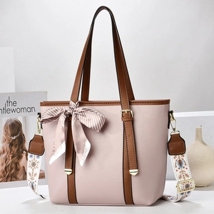 Pale pink bucket bag with wide ethnic strap and silk scarf detail for elegant women