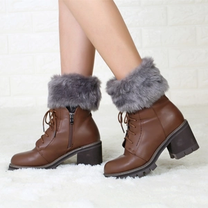 Detailed side view of brown chunky high heel boots with grey faux fur collar and laces
