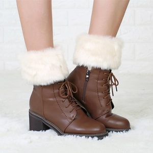 Detail of brown lace-up boots with plush white faux fur trim and side zipper closure