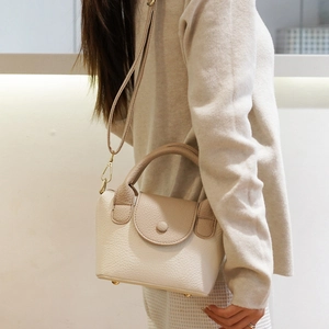 Chique beige lederen emmer tas met handvat en verstelbare schouderriem voor dames