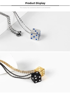 Detailed close-up of lucky dice pendants in silver, gold and black with O-link chain