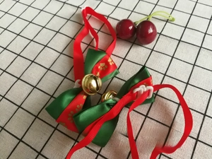 Dettaglio farfallino per animali rosso e verde con campanello dorato e stampe di zampe