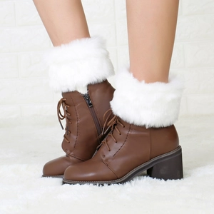 Close-up of brown synthetic leather boots with plush white faux fur trim and laces