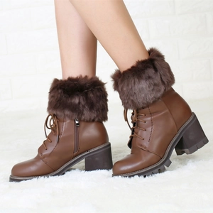 Macro detail of brown leather ankle boots with faux fur collar and side zipper closure