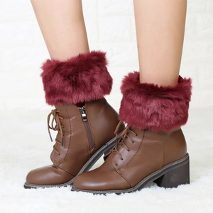 Detail of warm brown PU leather ankle boots with burgundy faux fur trim and side zipper