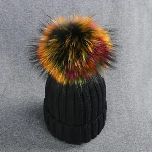 Close-up of thick ribbed knit beanie with a large colorful faux fur pom pom on top