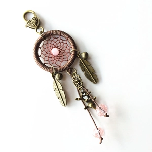Detail of dreamcatcher keychain with bronze feathers, deer charm and pink beads
