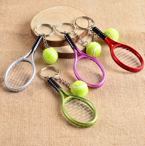 Detailed view of tennis racket keychains in silver, purple, red, and green colors