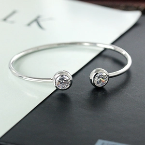 Close-up of minimalist silver open cuff bracelet featuring two sparkling zircon stones
