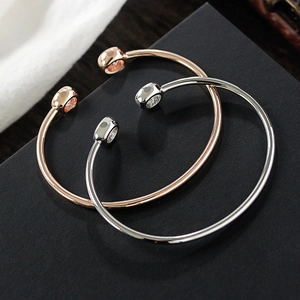 Minimalist open zircon bangle in rose gold and silver finish on matte background