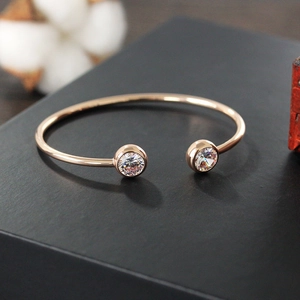 Detail of rose gold cubic zirconia open cuff bracelet on a black textured gift box
