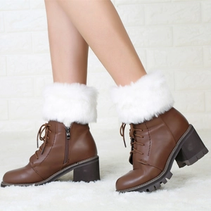 Detailed close-up of brown lace-up boots with plush white faux fur trim and high heels