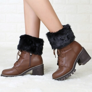 Close-up of brown lace-up boots with thick black faux fur trim and side zipper detail