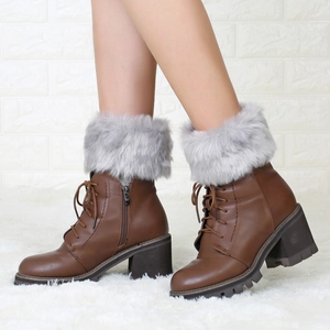 Detail view of brown faux fur trim and lace-up design on women's chunky heel boots
