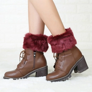 Detail of burgundy faux fur trim and side zipper on dark brown short winter boots