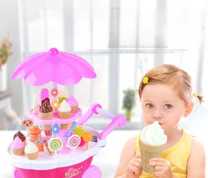Jeune enfant jouant avec un chariot de glaces rose avec lumières et fausses friandises