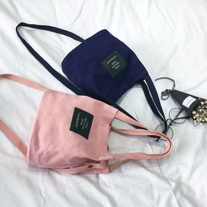 Minimalist canvas bucket crossbody bag for women with dual top handles and long strap